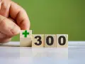 Dłoń układa kostkę z zielonym plusem obok kostek z napisem "300". To dobry start dla kogoś, kto chce zacząć coś nowego.