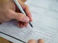 Dłoń z długopisem wypełnia formularz. Warto wiedzieć, jak znaleźć numer NIP, by poprawnie uzupełnić dokumenty.