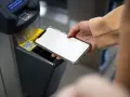 Dłoń zbliża smartfon do czytnika biletów. Szybkie płatności przez Euronet, bez prowizji PKO.