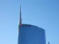 Szklany wieżowiec UniCredit z charakterystycznym logo, sięgający ku błękitnemu niebu. To symbol nowoczesności, jakby z przyszłości, niczym z wizji Aion Bank.