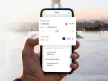 Dłoń trzyma smartfon z aplikacją kantoru. Widoczny kurs wymiany PLN na EUR.