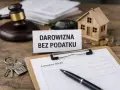 Formularz SD-Z2 czeka na wypełnienie. Klucze do domu, model domu i monety sugerują zgłoszenie darowizny bez podatku.