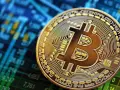 Złoty Bitcoin na tle wykresu giełdowego. To symbol tego, czym są kryptowaluty i jak działają.