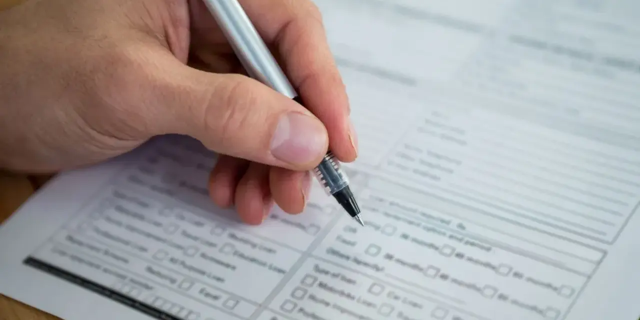 Dłoń z długopisem wypełnia formularz. Warto wiedzieć, jak znaleźć numer NIP, by poprawnie uzupełnić dokumenty.