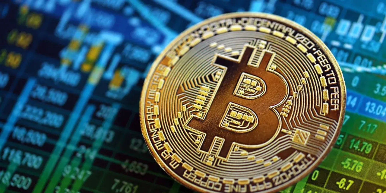 Złoty Bitcoin na tle wykresu giełdowego. To symbol tego, czym są kryptowaluty i jak działają.