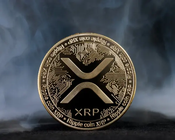 Złoty token kryptowaluty XRP, otoczony mgłą, symbolizuje przyszłość finansów.