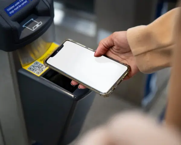 Dłoń zbliża smartfon do czytnika biletów. Szybkie płatności przez Euronet, bez prowizji PKO.