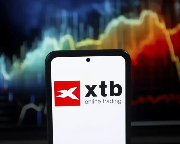 Telefon z logo XTB online trading na tle wykresu giełdowego. Czy XTB jest bezpieczne? Analiza rynku.