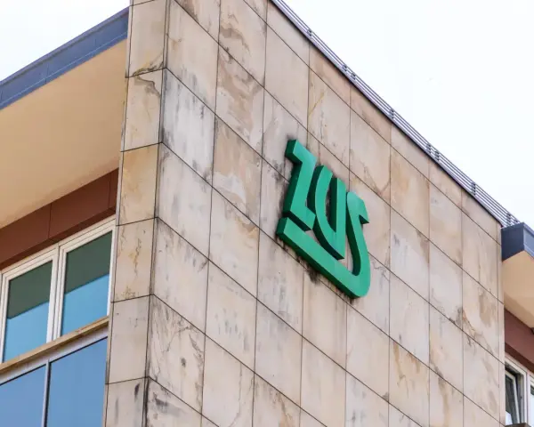 Budynek ZUS z zielonym logo. Zastanawiasz się, czy umowa zlecenie wlicza się do lat pracy do emerytury?