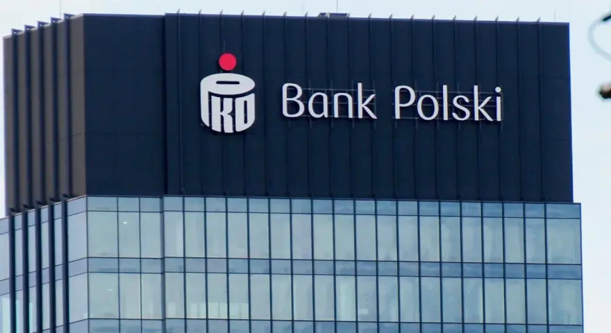 Logo PKO BP na ciemnym budynku. Widoczny napis "Bank Polski".