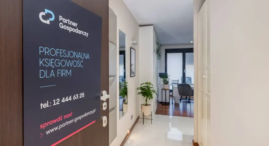 Tabliczka na drzwiach z logo "Partner Gospodarczy" i hasłem "Profesjonalna księgowość dla firm".