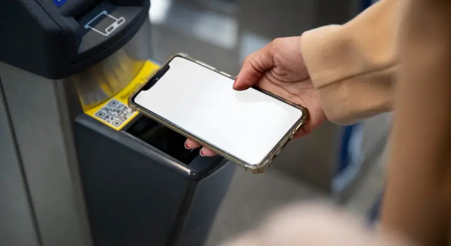 Dłoń zbliża smartfon do czytnika biletów. Szybkie płatności przez Euronet, bez prowizji PKO.