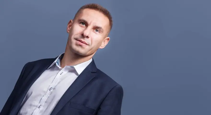Mężczyzna w garniturze i białej koszuli, patrzący w górę.