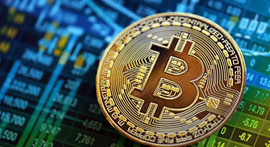 Złoty Bitcoin na tle wykresu giełdowego. To symbol tego, czym są kryptowaluty i jak działają.