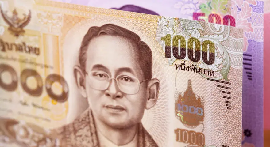 Tajskie baty: banknot 1000 bahtów z wizerunkiem króla i banknot 500 bahtów w tle.