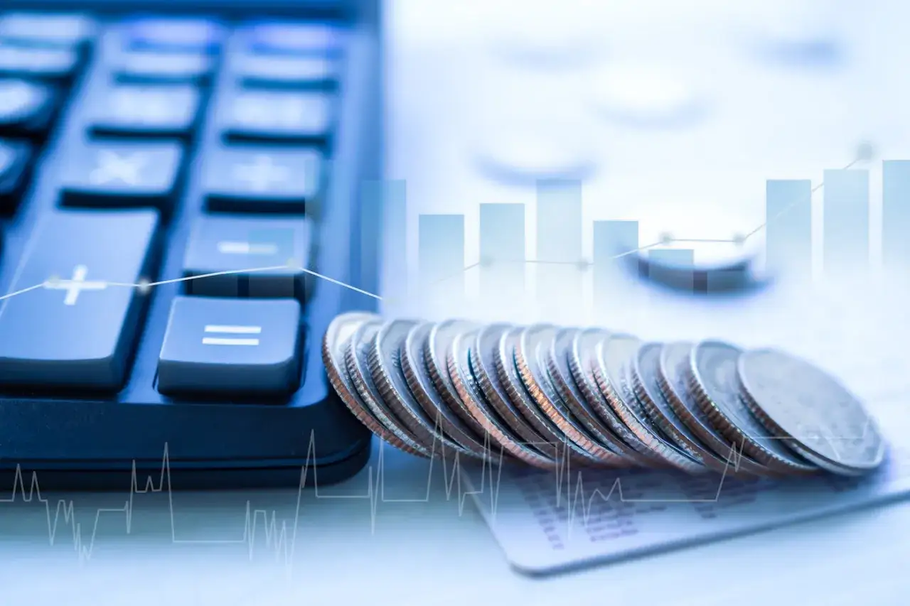 Kalkulator, monety i wykresy symbolizują finanse. Współwłaściciel konta bankowego a urząd skarbowy - rozliczenia i podatki.
