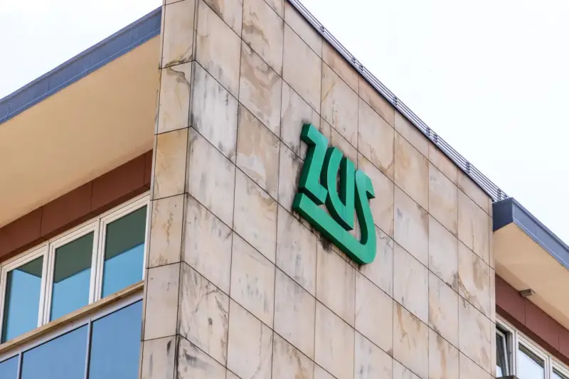 Budynek ZUS z zielonym logo. Zastanawiasz się, czy umowa zlecenie wlicza się do lat pracy do emerytury?
